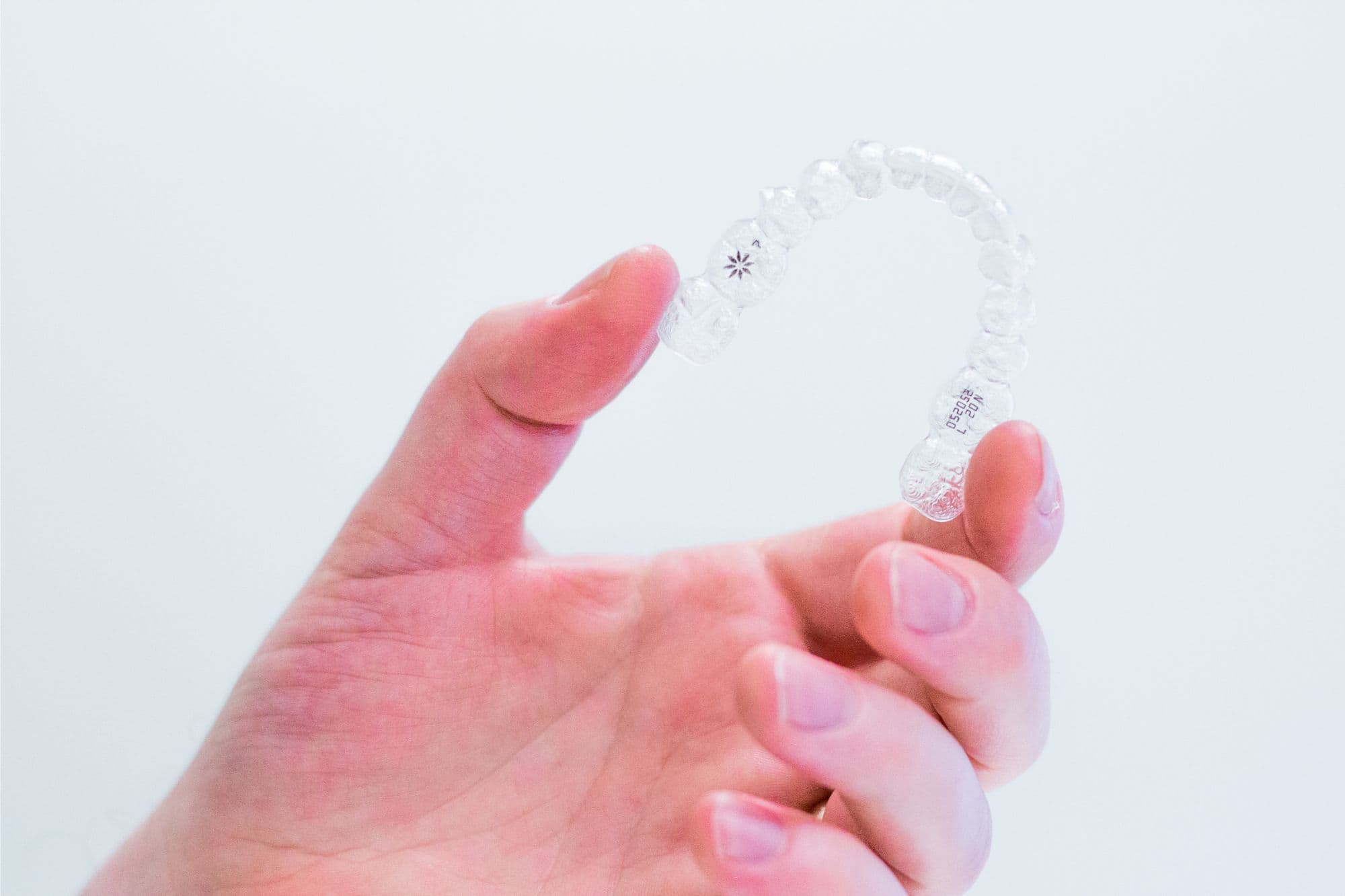 Hand holding Invisalign aligners
